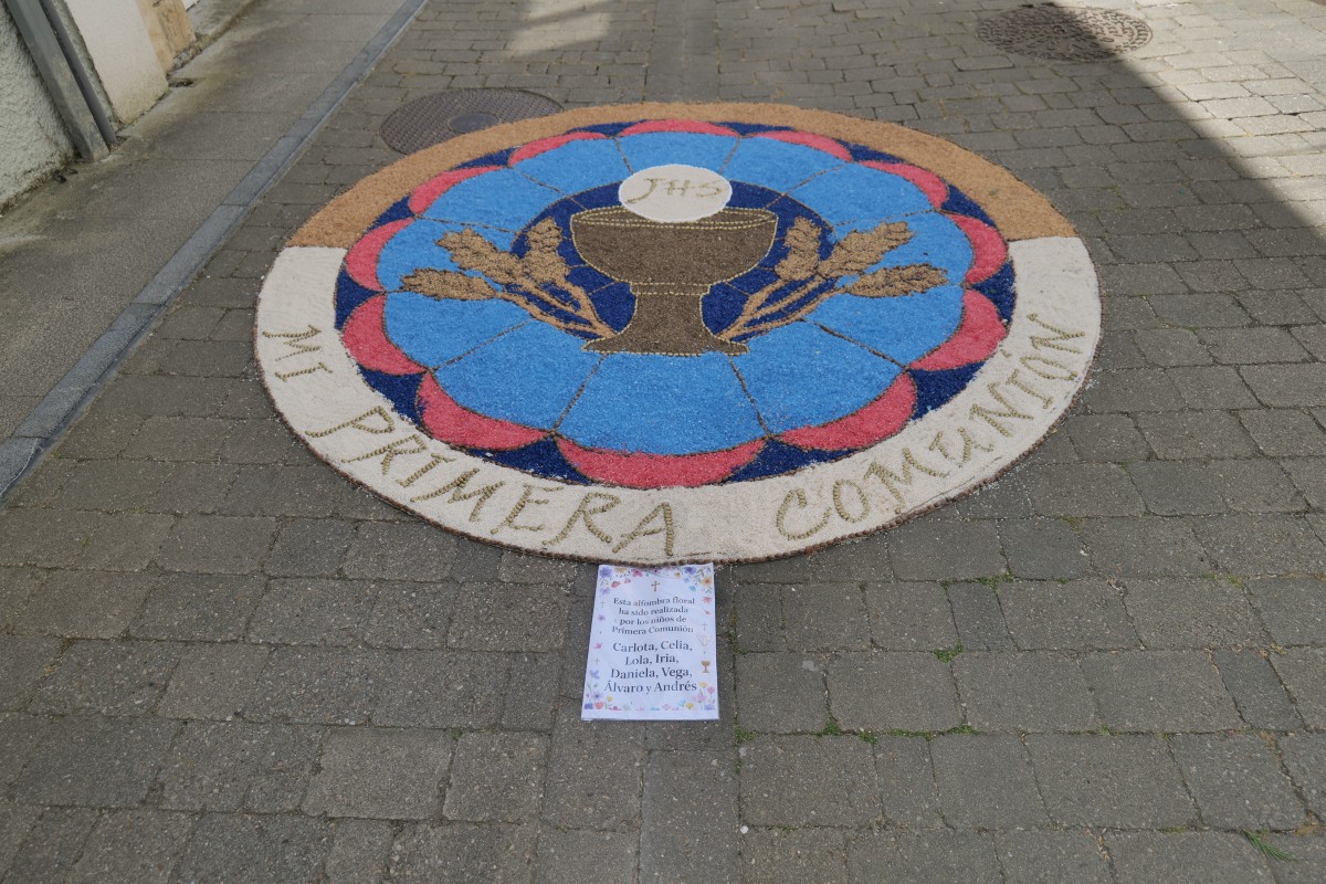 First Communion sidewalk flower display with a chalice and wheat, labeled “Mi Primera Comunión”